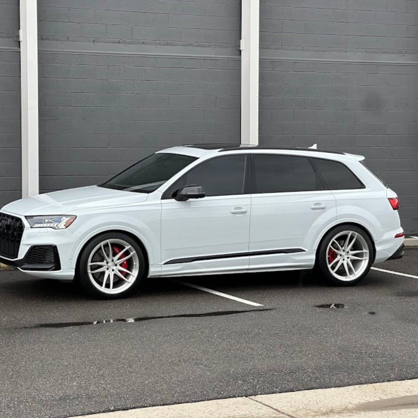 White Audi SQ7 luxury SUV parked in a lot, featuring performance upgrades from HS Tuning.