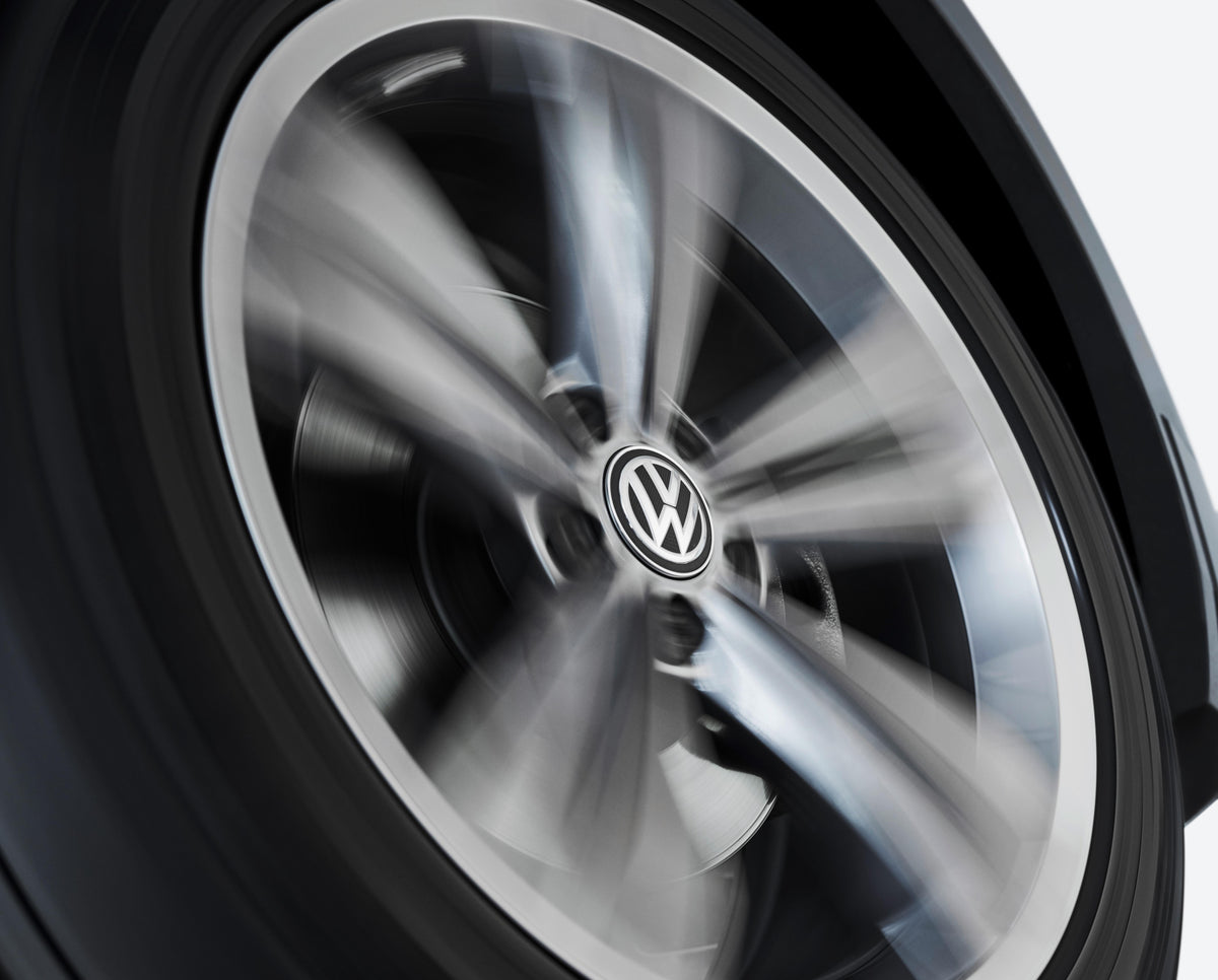 Genuine VW/Audi 000-071-213-C self-leveling center cap shown on a rotating wheel; wheel not included