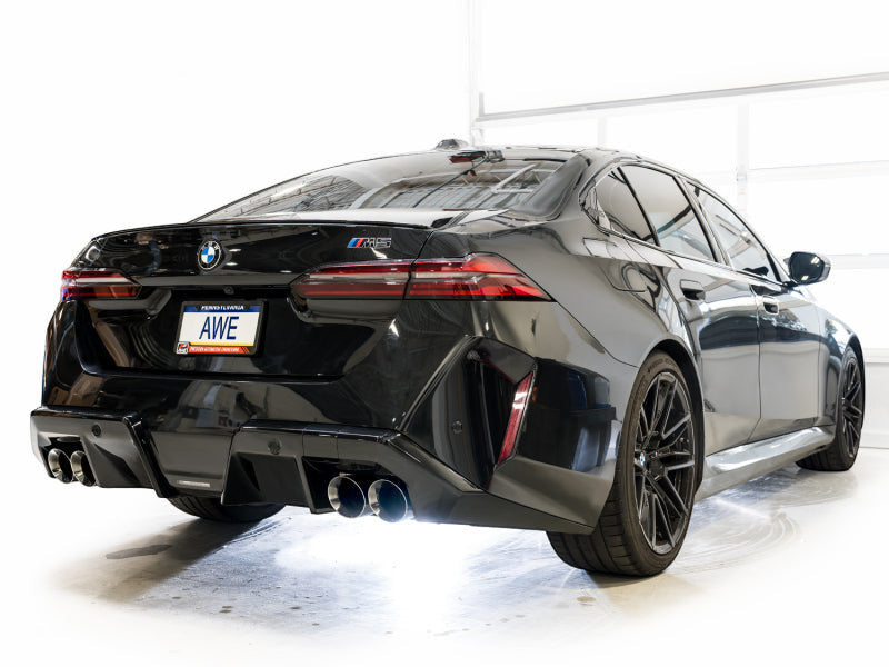 HS Tuning AWE Tuning Track Edition cat-back exhaust with chrome silver tips installed on a black BMW M5 rear view