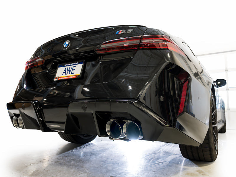 HS Tuning AWE Tuning Track Edition cat-back exhaust with chrome silver tips installed on a black BMW G90 M5 rear view
