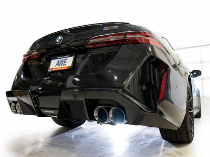 HS Tuning AWE Tuning Track Edition cat-back exhaust with chrome silver tips installed on a black BMW G90 M5 rear view