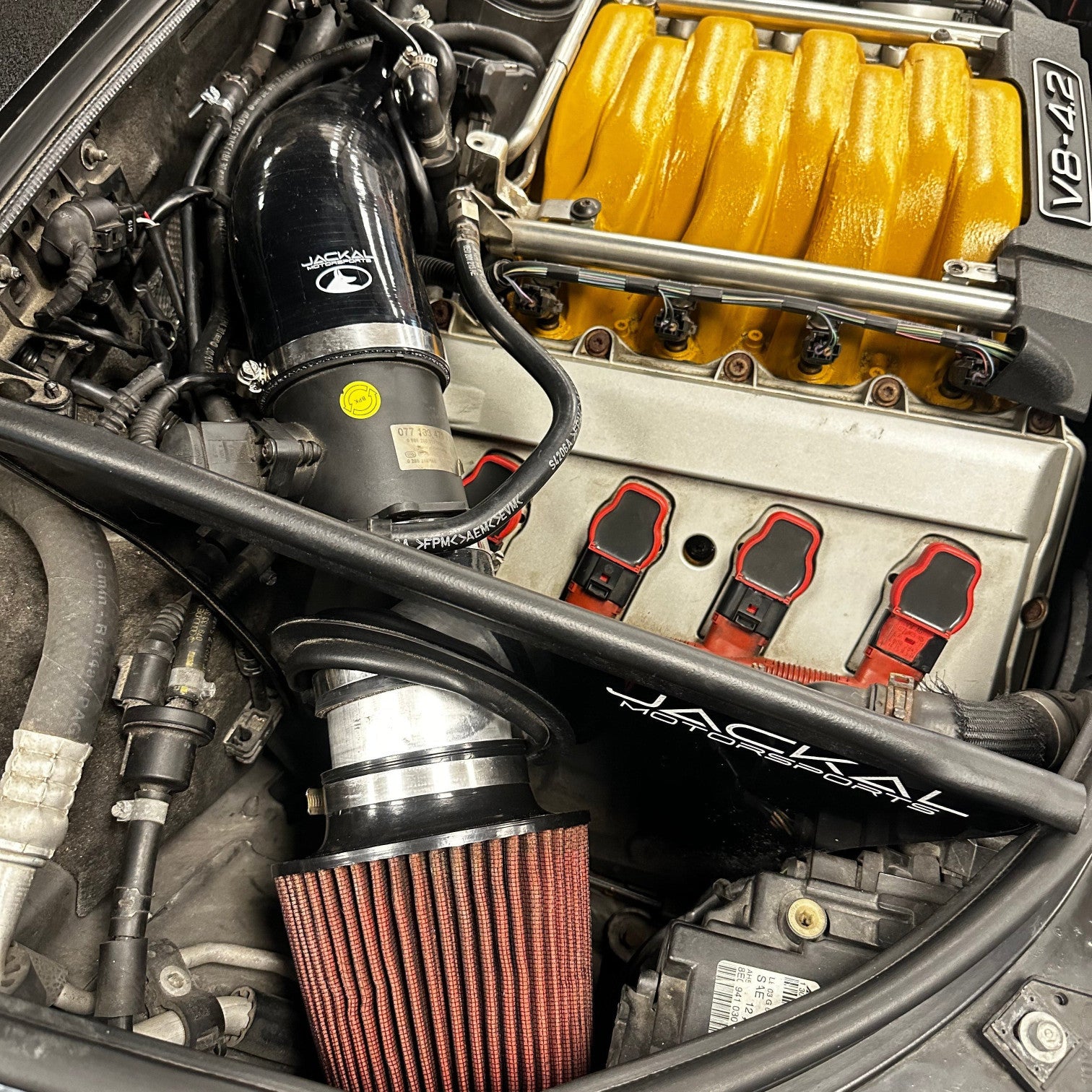 HS Tuning Jackal Motorsports air intake system installed in an Audi B6/B7 S4 engine bay with a yellow intake manifold.